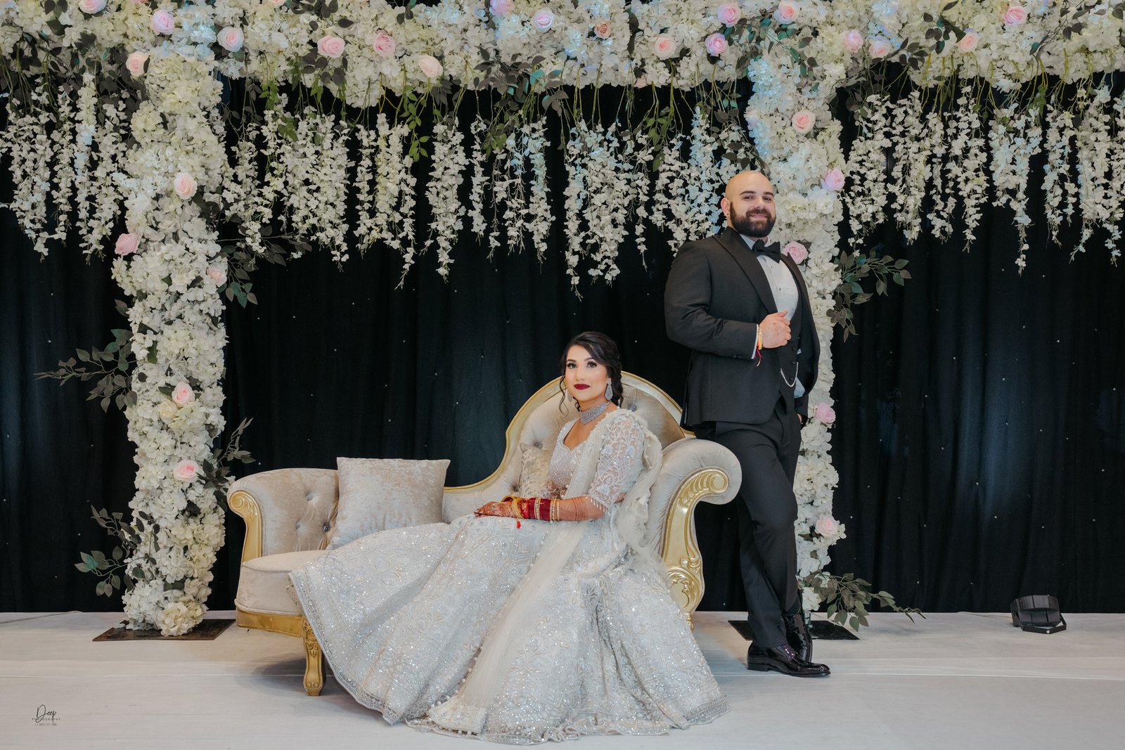 Newlyweds dancing under romantic lights at reception