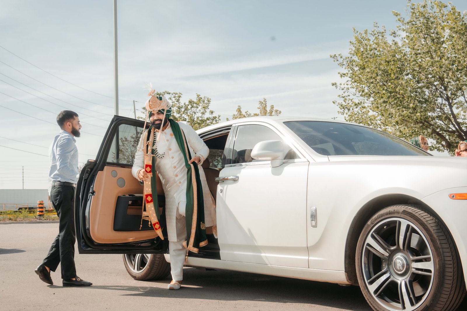 Groom stepping out of a wedding car at the ceremony entrance
